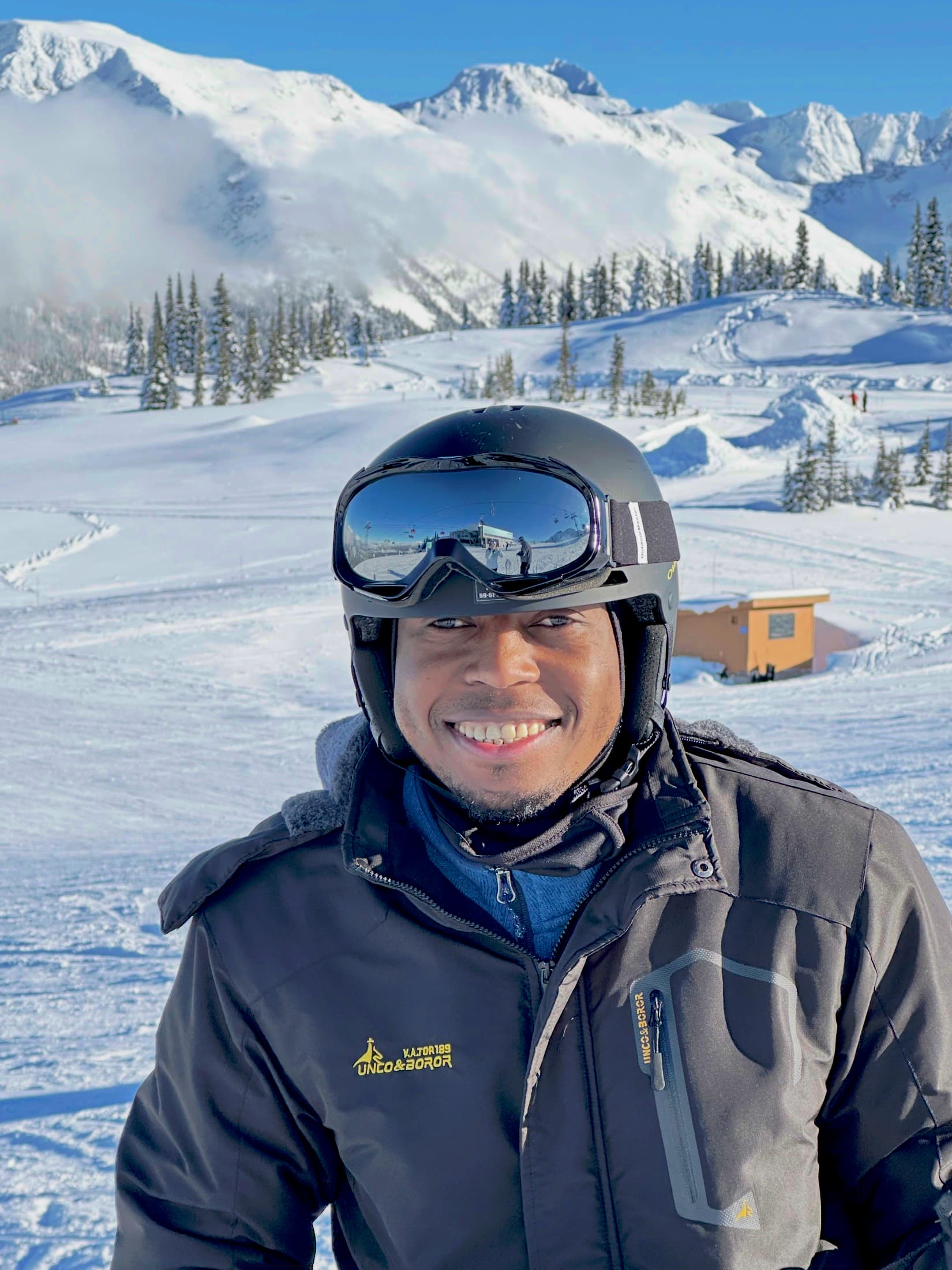 Richard on the mountain at Whistler, snow and peaks behind him